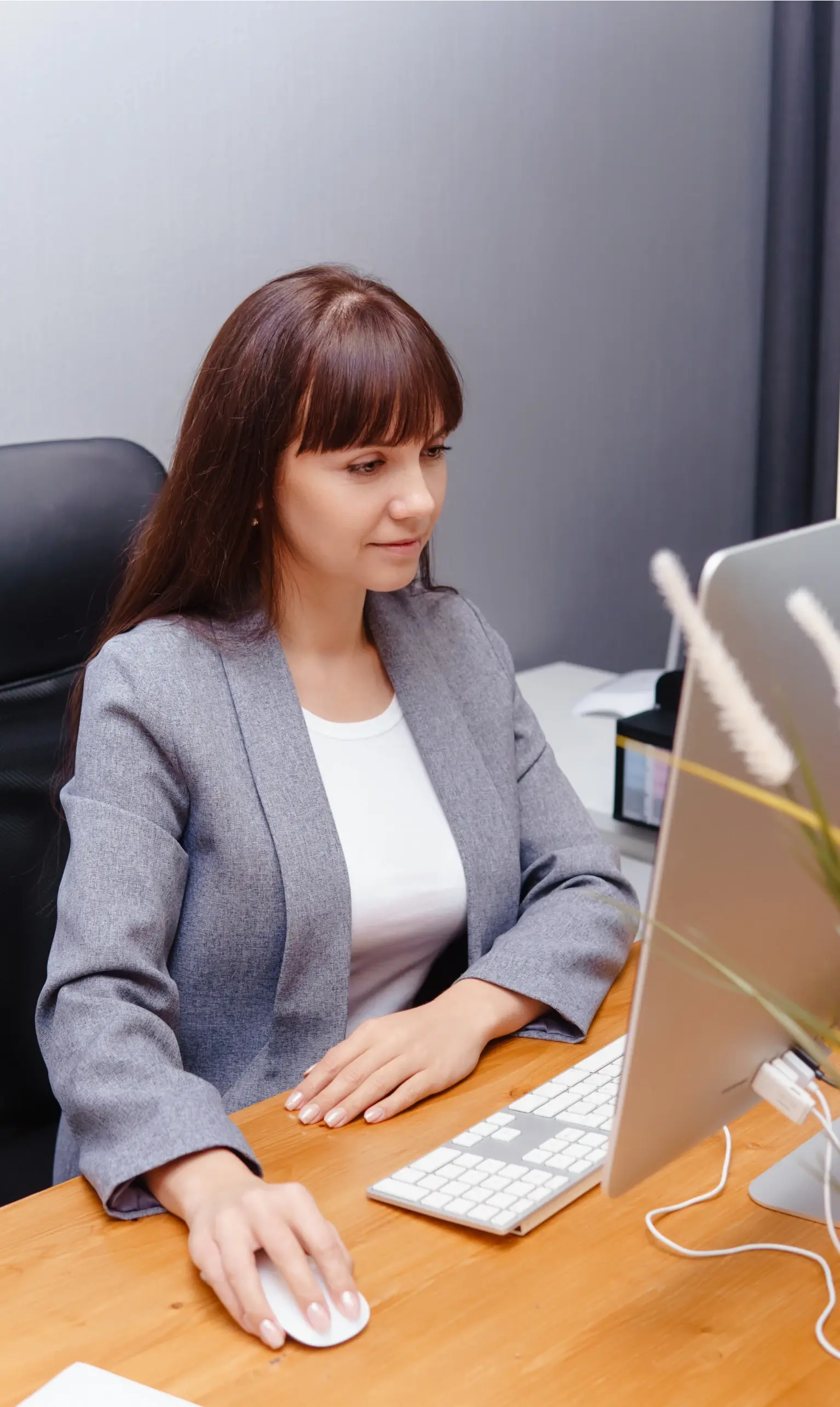 Professional woman looking at desktop computer in office