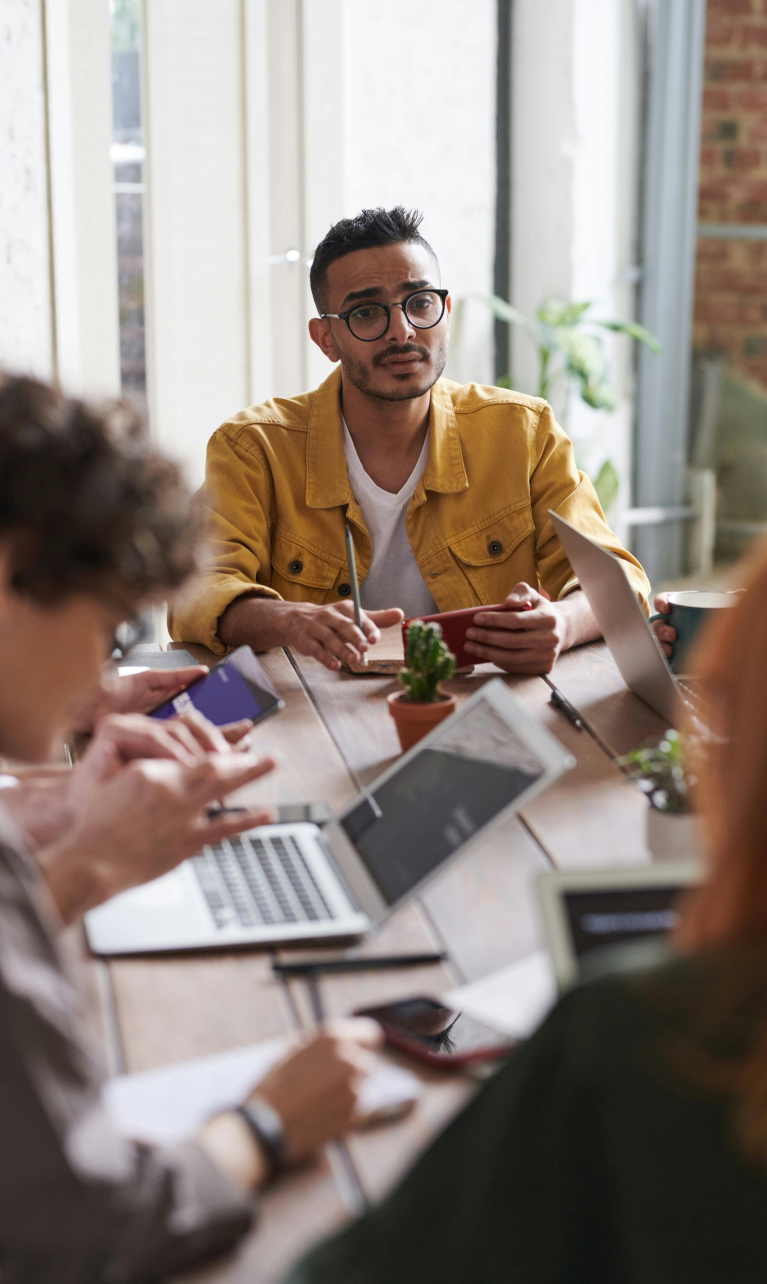 Teams of sales people sitting at a conference table