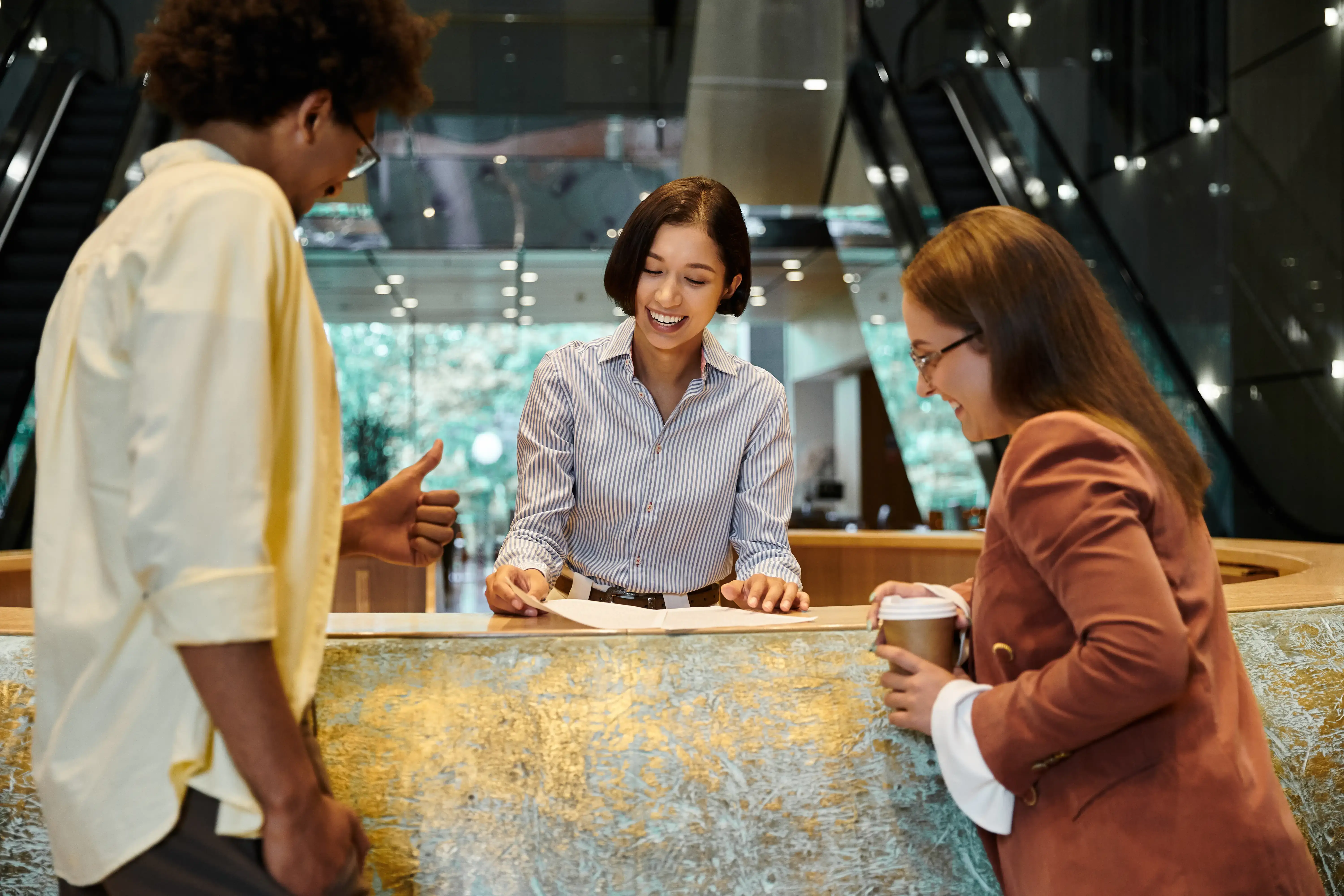 Woman at help desk of hotel helping a young couple