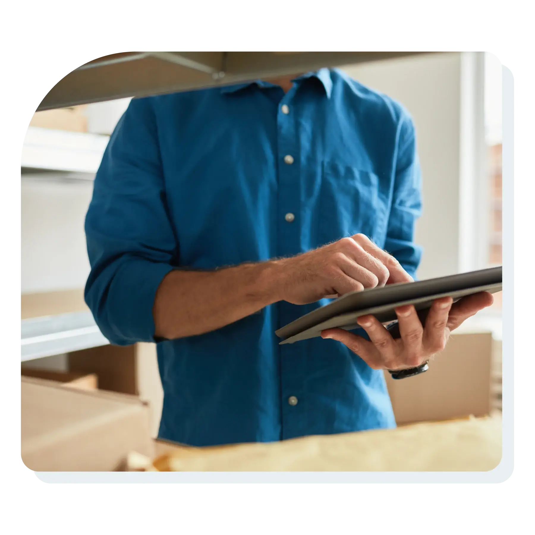 man_holding_ipad_in_a_room_full_of_shipping_boxes