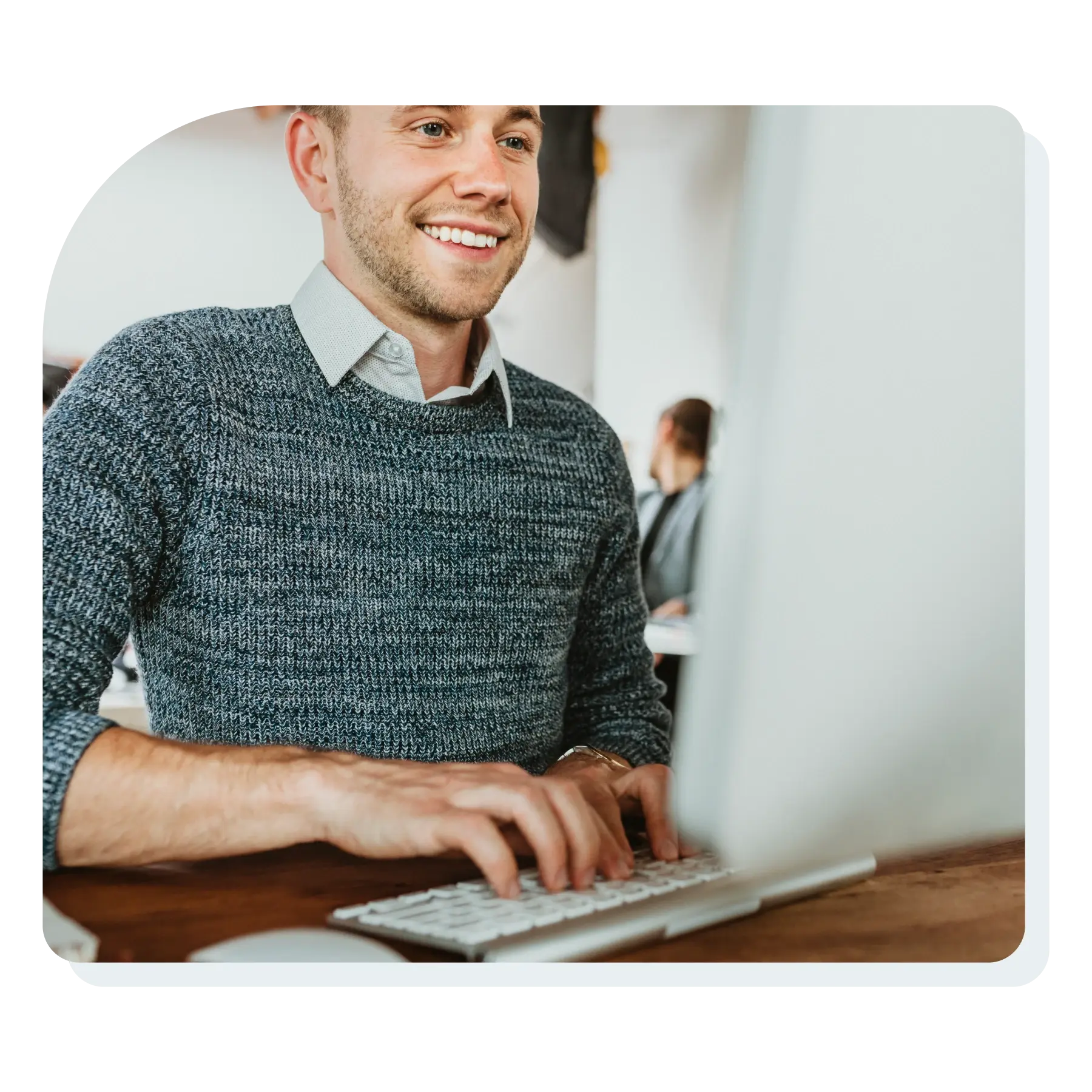 man_working_on_desktop_computer_smiling