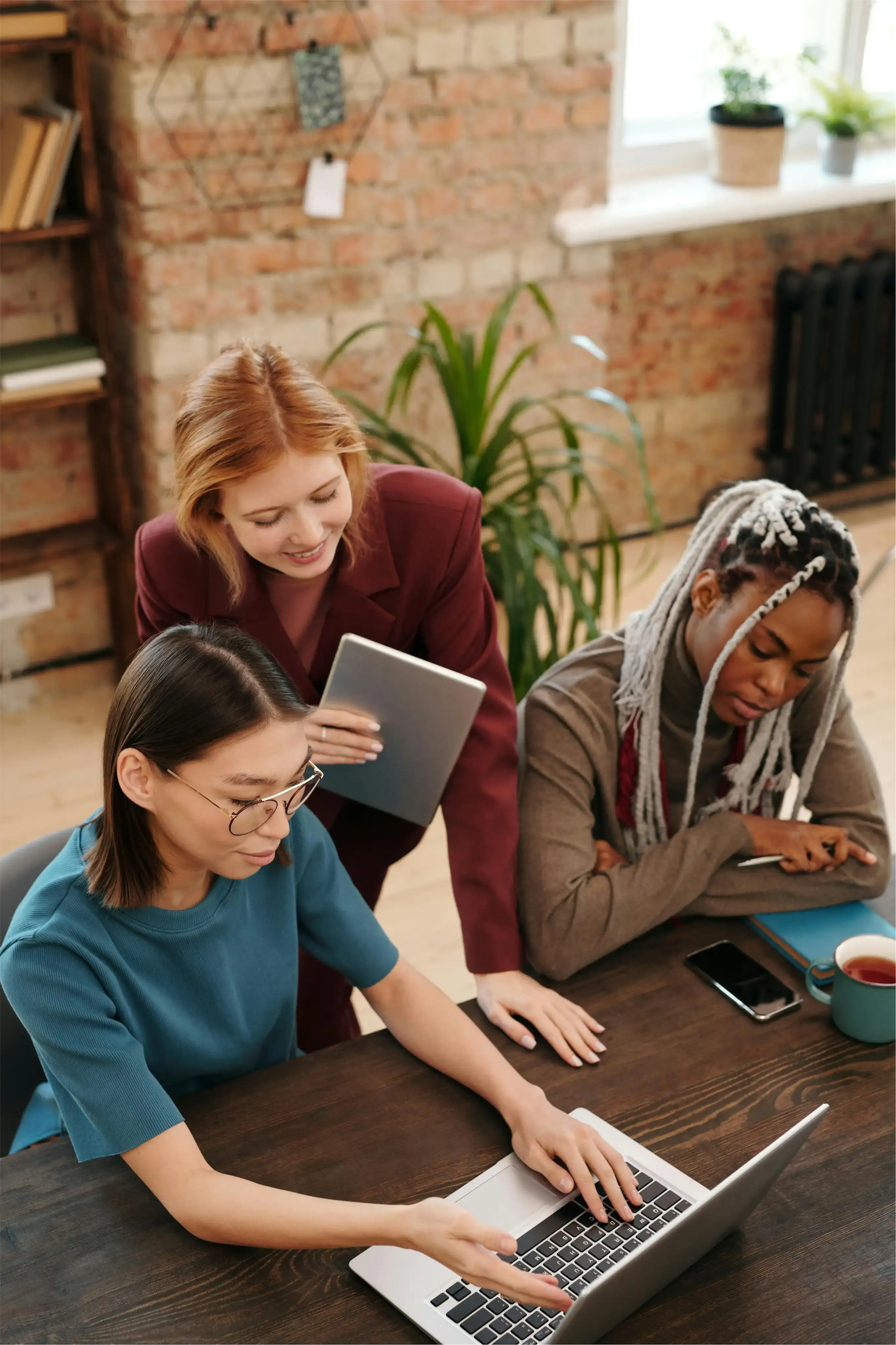 Group of women workers looking at a laptop smiling