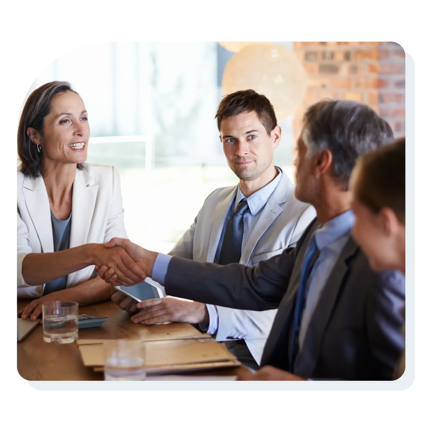 team_smiling_making_a_sales_deal_at_a_conference_table