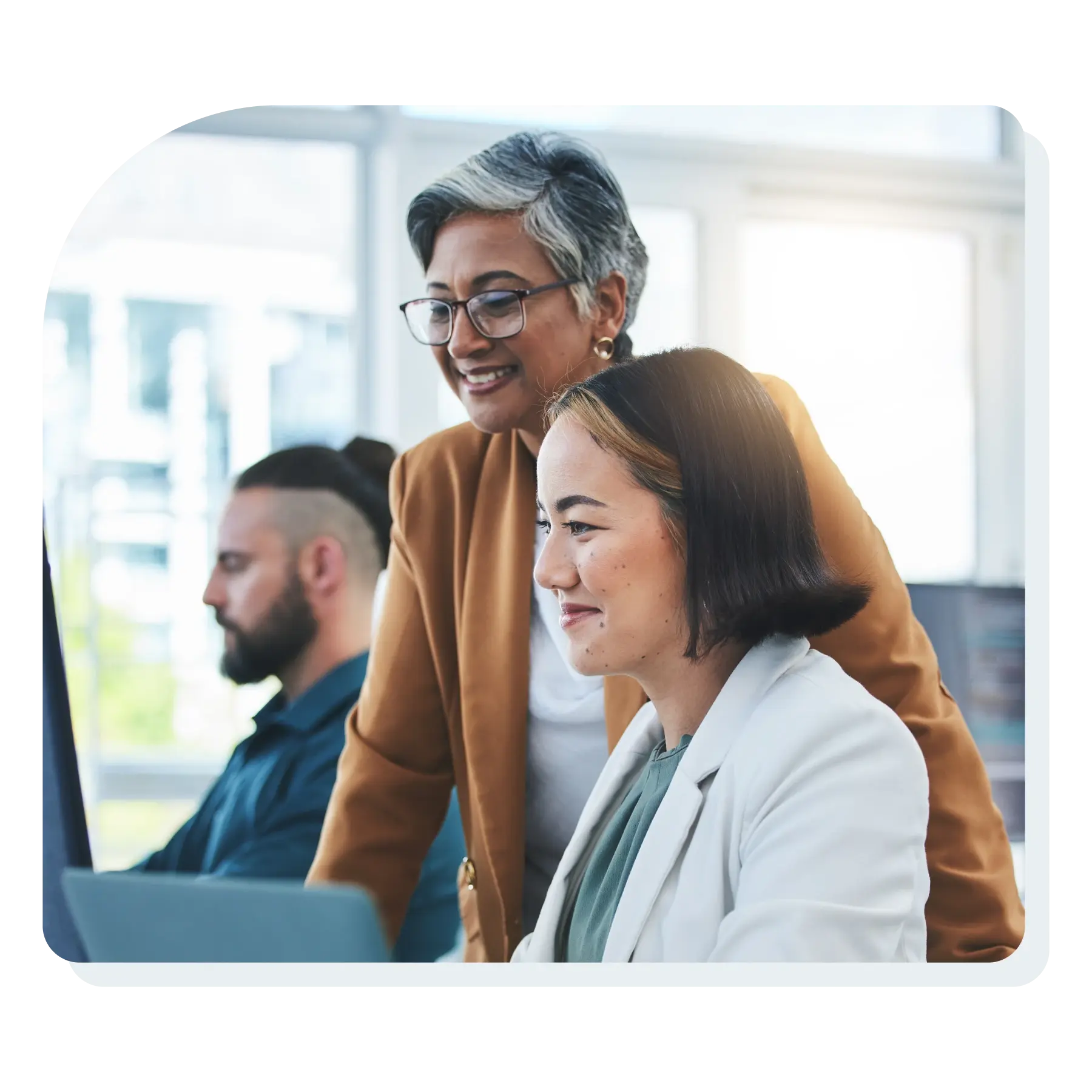 two_women_smiling_looking_at_a_computer_screen_at_work