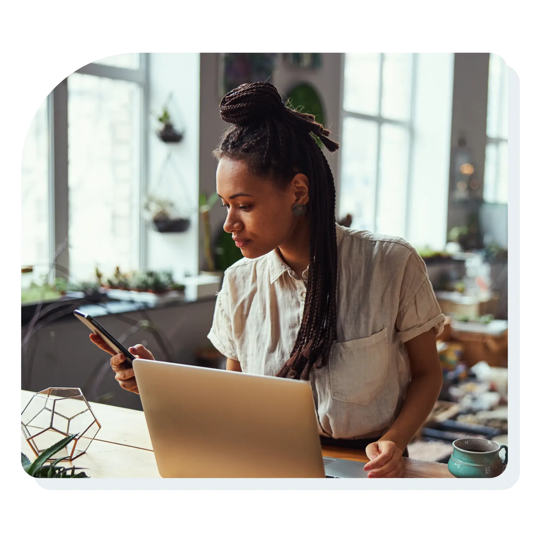 woman_looking_at_phone_while_working_at_computer